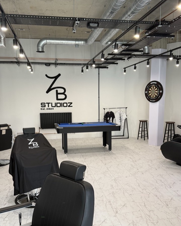 Inside ZB Studioz — pool table, barber chairs and the ZB logo on the wall